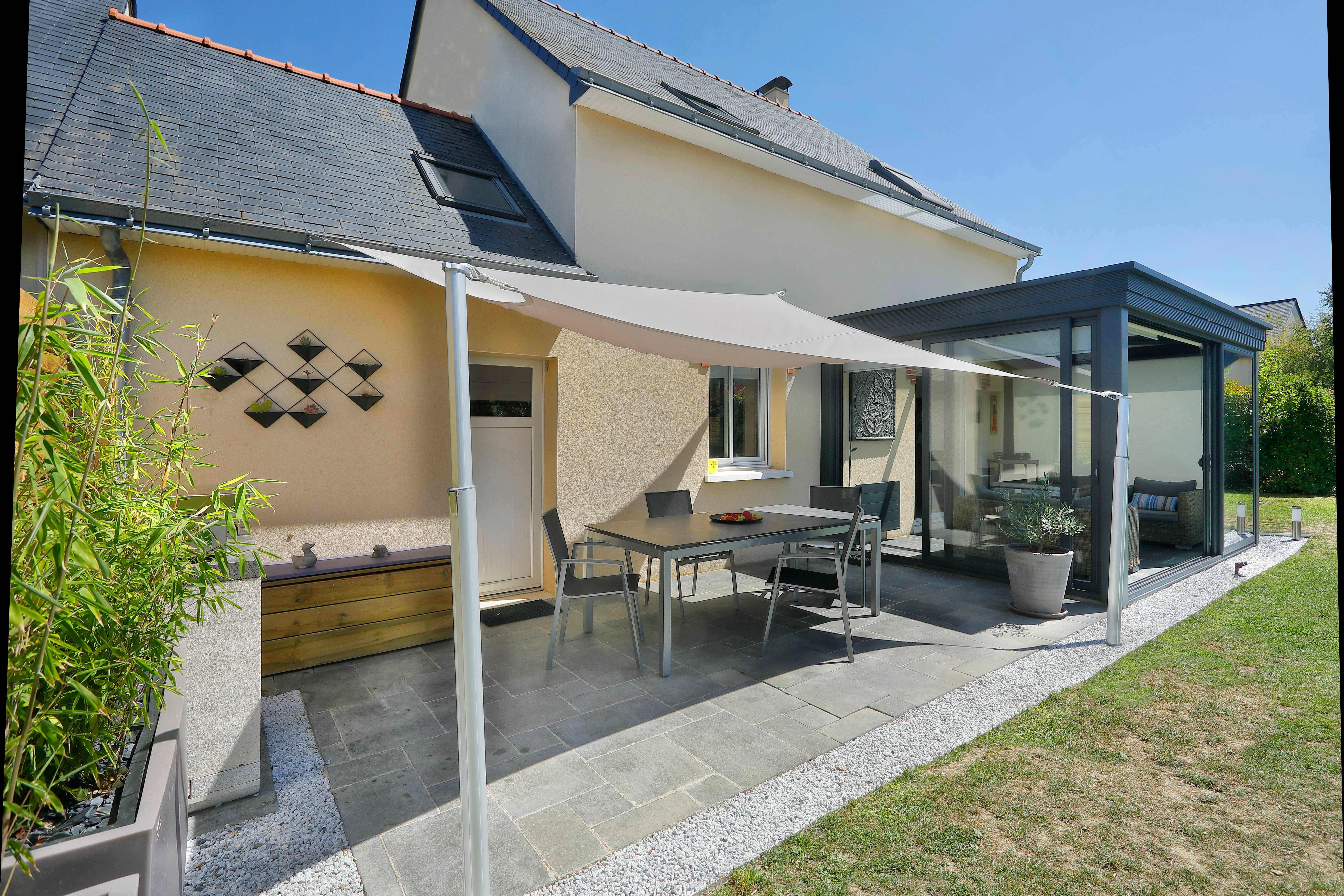 Vela ombreggiante che protegge una zona pranzo dai raggi solari nocivi