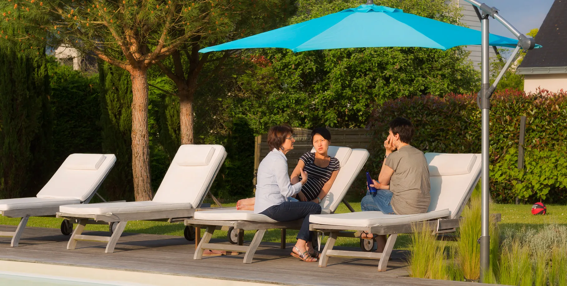 ombrellone decentrato al centro di un’aiuola fiorita senza piastre di zavorra, fissaggio discreto e libero