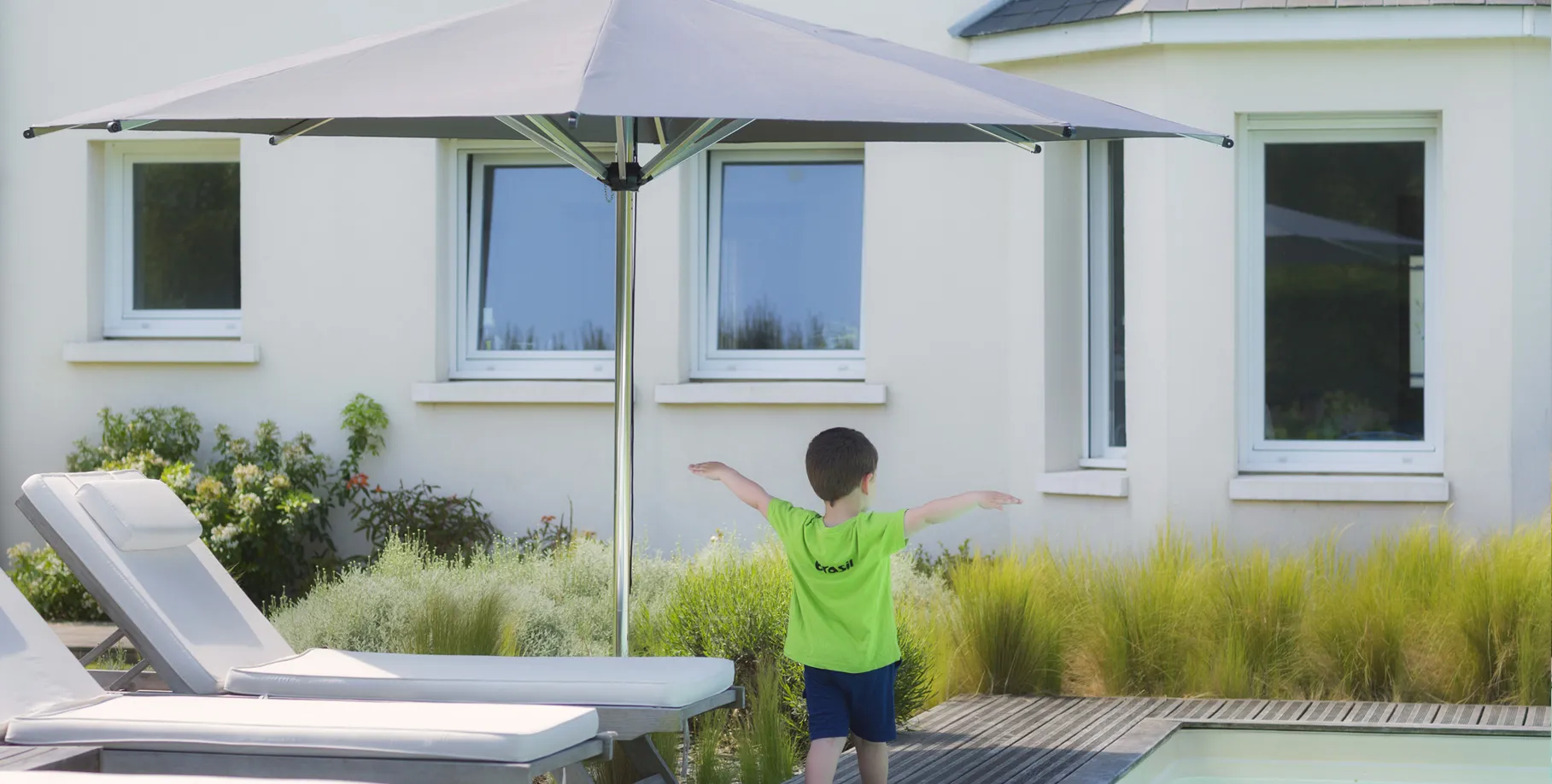 ombrellone centrale installato vicino alla piscina con supporto Gard&Rock integrato nel suolo, senza ingombro visibile