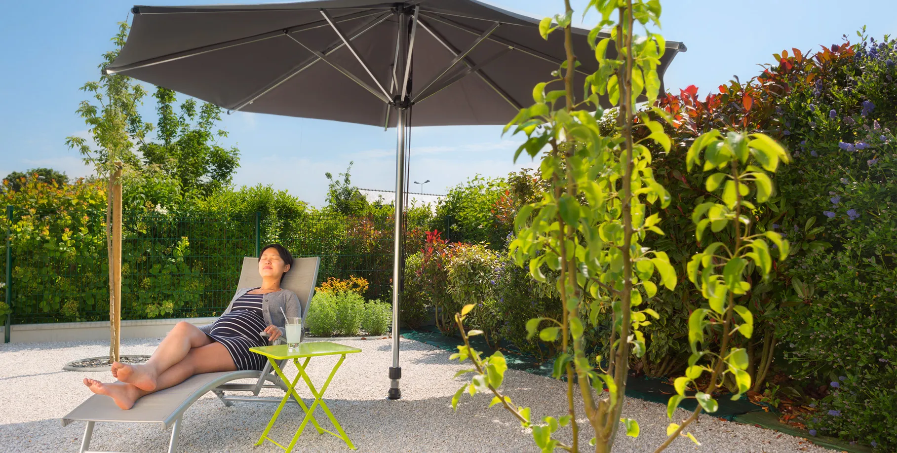 supporto per ombrellone installato su ghiaia in area pranzo esterna, senza piastre né base ingombrante