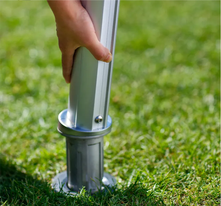 mano che tiene palo per vela ombreggiante pronto per l’ancoraggio in base sigillata a terra