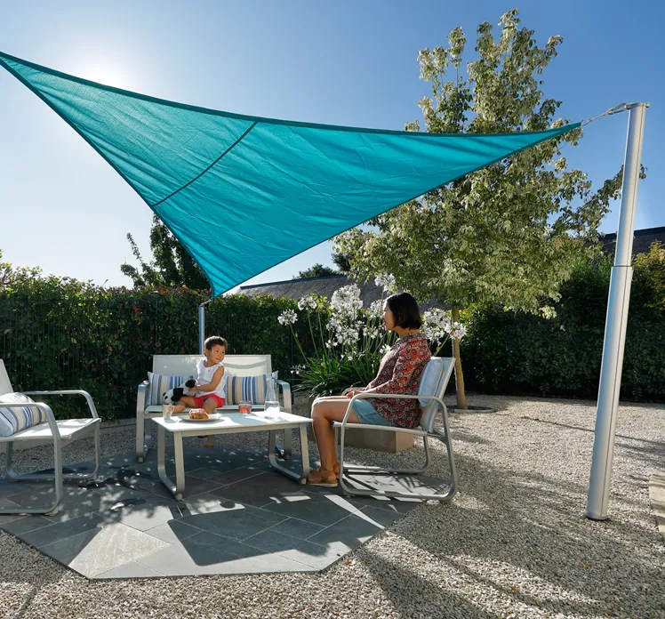 vela ombreggiante triangolare tesa su tre pali di altezze diverse per un effetto pergola elegante e regolabile
